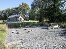 An outdoor area with a picnic table and logs at Cadno Llanybydder