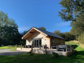 A cabin with a deck and hot tub at Cadno Aber near Llanybydder