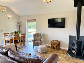 A living room with a dining area and fireplace at Cadno near Llanybydder