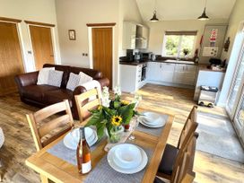 An open plan living space with a dining table and kitchen area at Cadno Aber near Llanybydder