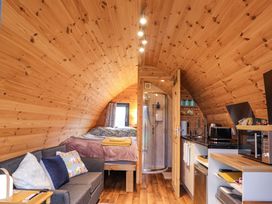 A studio with a bed, sofa, shower, and kitchen counter at The Pod at Greenbank Isle of Skye
