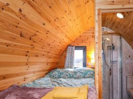 A bedroom with a bed and shower at The Pod at Greenbank Isle of Skye