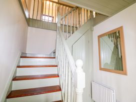 A staircase with a handrail and mirror at Shamrock House in 