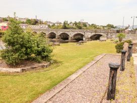 A park with a stone bridge and benches at Shamrock House, Killorglin, County Kerry