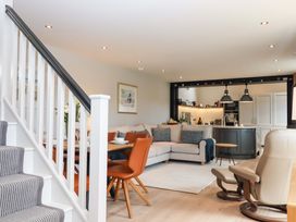 A living room with a staircase and kitchen island at Duke's Barn Blackawton near Dartmouth