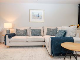 A living room with a sofa and decorative cushions at Duke's Barn in Blackawton near Dartmouth