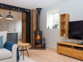 A living room with a stove and a tv at Duke's Barn Blackawton near Dartmouth