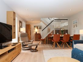 A living room with a television and dining area at Duke's Barn in Blackawton near Dartmouth