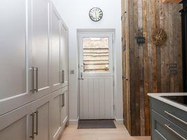 A kitchen with cabinets and an entrance door at Duke's Barn Blackawton near Dartmouth