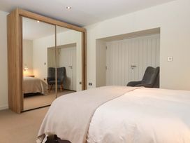 A bedroom with a bed and a chair at Duke's Barn in Blackawton near Dartmouth