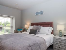 A bedroom with a bed and nightstand at Duke's Barn near Blackawton