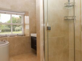 A bathroom with a bathtub, shower, and sink at Duke's Barn in Blackawton near Dartmouth