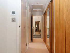A hallway with a thermostat and mirrored wardrobe at Duke's Barn in Blackawton near Dartmouth