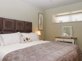 A bedroom with a bed and a mirror at Duke's Barn near Dartmouth