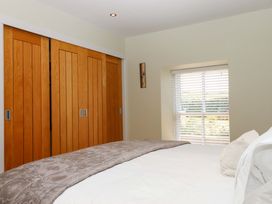 A bedroom with a bed and closet doors at Duke's Barn in Blackawton near Dartmouth
