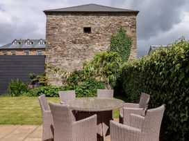 A garden with a stone wall and dining set at Duke's Barn near Dartmouth