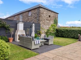 A garden with a seating area and fireplace at Duke's Barn in Blackawton near Dartmouth