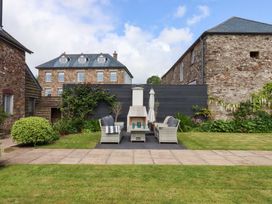 A garden with lounge chairs and outdoor fireplace at Duke's Barn Blackawton near Dartmouth