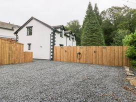 An outdoor area with gravel parking and trees at Catbells in Windermere