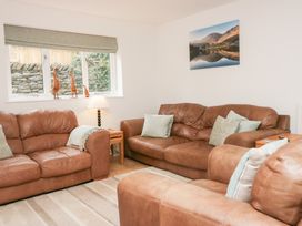 A living room with brown sofas and a lamp at Catbells in Windermere