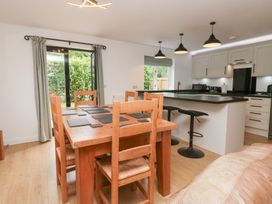 A dining area with wooden table and bar stools at Catbells in Windermere