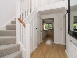 A hallway with a staircase leading to an upper floor at Catbells in Windermere