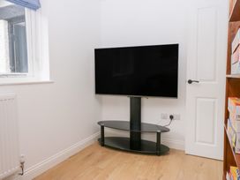 A living room with a television mounted on a stand at Catbells in Windermere