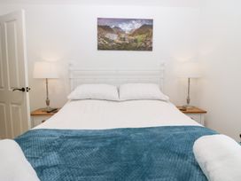 A bedroom with a bed, nightstand, and lamp at Catbells in Windermere