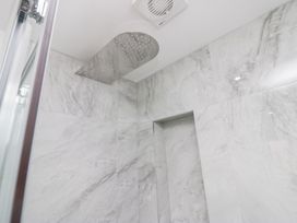 A bathroom with a shower and tiled walls at Catbells, Windermere