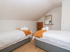 A bedroom with two beds and a wardrobe at Catbells in Windermere