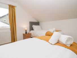 A bedroom with two beds and a lamp on a nightstand at Catbells in Windermere
