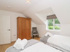 A bedroom with two beds and a wardrobe at Catbells Windermere