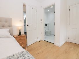 A bedroom with a bed and doorway leading to a bathroom at Catbells in Windermere