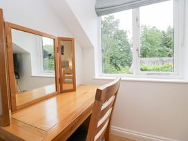 A dressing table and window with trees outside at Catbells in Windermere