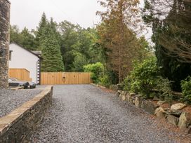An outdoor space with a gravel driveway and trees at Catbells in Windermere