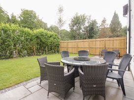 A garden with a table and chairs at Catbells in Windermere