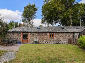 An outdoor view of a stone cottage with a patio at The Coach House in Tavistock