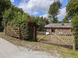 A cottage with a wooden gate and fence at The Coach House in Tavistock