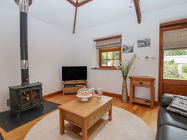 A living room with a stove and television at The Coach House in Tavistock