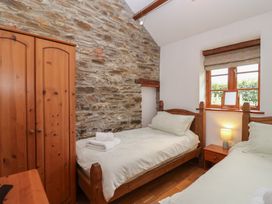 A bedroom with two beds and a wardrobe at The Coach House in Tavistock