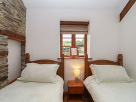 A bedroom with two beds and a window at The Coach House in Tavistock