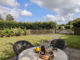 A garden with a table, chairs, and plants at The Coach House in Tavistock