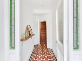 A hallway with a staircase and mirror at The Sundial in St Austell