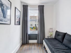 A living room with a sofa and window at The Sundial in St Austell