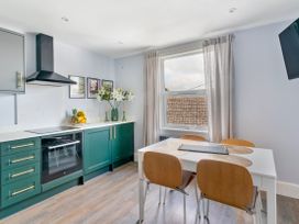 A kitchen with a dining table and chairs at The Sundial in St Austell