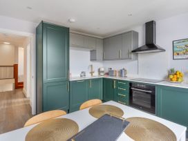 A kitchen with cabinets and appliances at The Sundial in St Austell