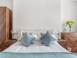 A bedroom with a bed and nightstands at The Sundial in St Austell