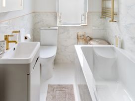 A bathroom with a bathtub, toilet, sink and towel rack at The Sundial in St Austell