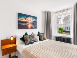A bedroom with a bed and a window at The Sundial in St Austell