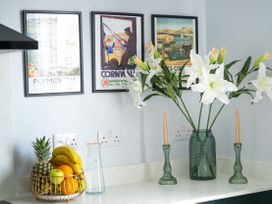 A kitchen counter with fruit bowl and floral arrangement at The Sundial in St Austell